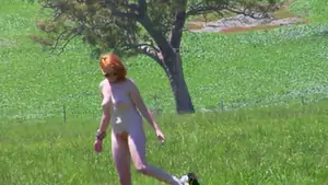 Peliroja desnuda en el campo