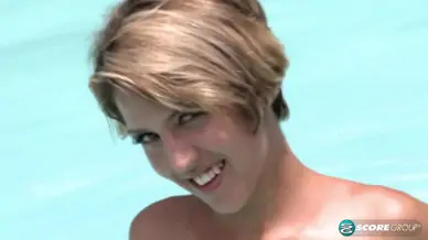 Aliha aldamen tans her fair skin outside by the pool while wearing a blue and white striped bikini